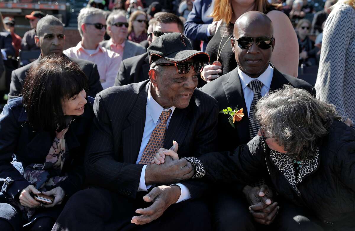 Deb Perry, wife of Gaylord Perry, right, reaches over to shake hands with Willie Mays during a public remembrance for Willie McCovey at AT&T Park in San Francisco, Calif., on Thursday, November 8, 2018.