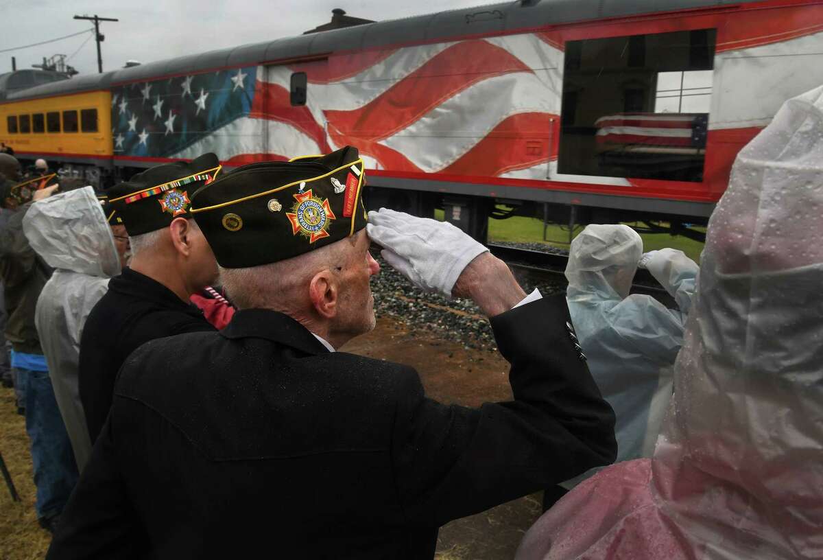 Retired Air Force Staff Sgt. Carl Dry salutes Thursday as the flag-draped casket of former president George H.W. Bush travels by train through Navasota, Texas, on its way to College Station for burial.