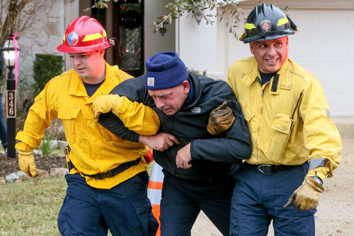 Firefighters rescue a resident, played by an instructor, on Thursday, Dec. 6, 2018 during a wildfire training exercise in the Roseheart neighborhood on the North Side.