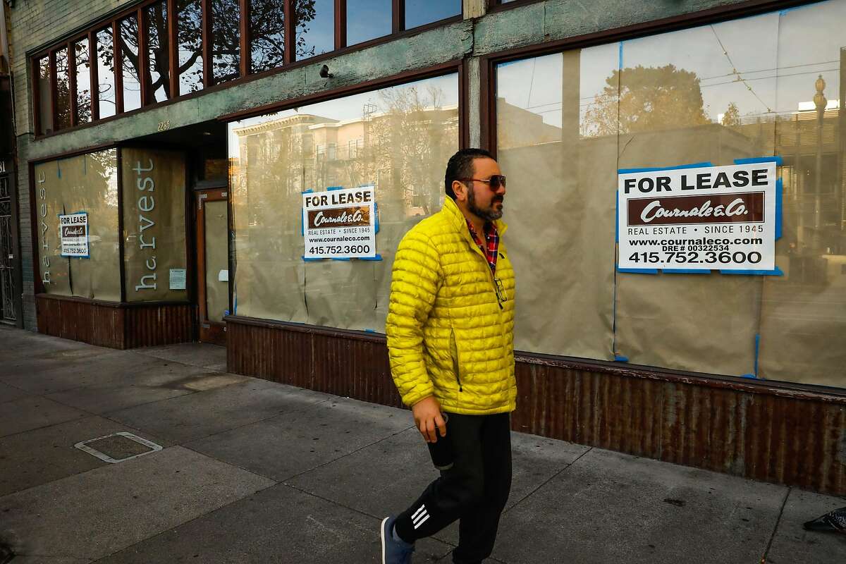 A person passes by a shuttered storefront on Market Street in the Castro, a neighborhood in San Francisco that's been hit hard by retail vacancies, on Monday, Oct. 29, 2018.