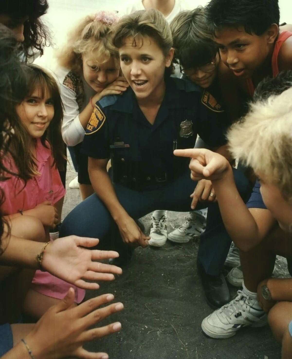 San Antonio police officer Holly Vizcarrondo, then known as Holly Cheatham, with a group of children in the 1990s.