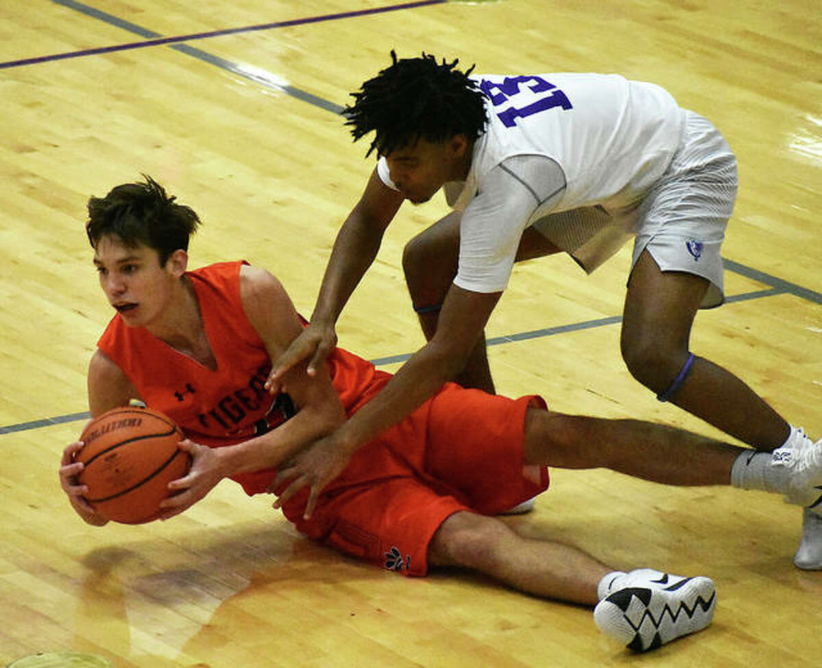 Edwardsville’s Brennan Weller shields the ball away from Collinsville’s Ray’Sean Taylor in the third quarter.