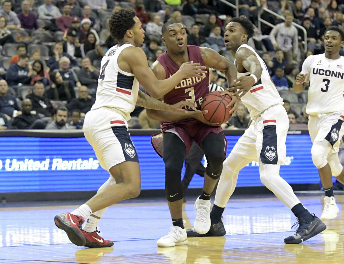 Florida State’s Trent Forrest (3) attempts to split the defense of UConn’s Jalen Adams, left, and Tarin Smith on Saturday.