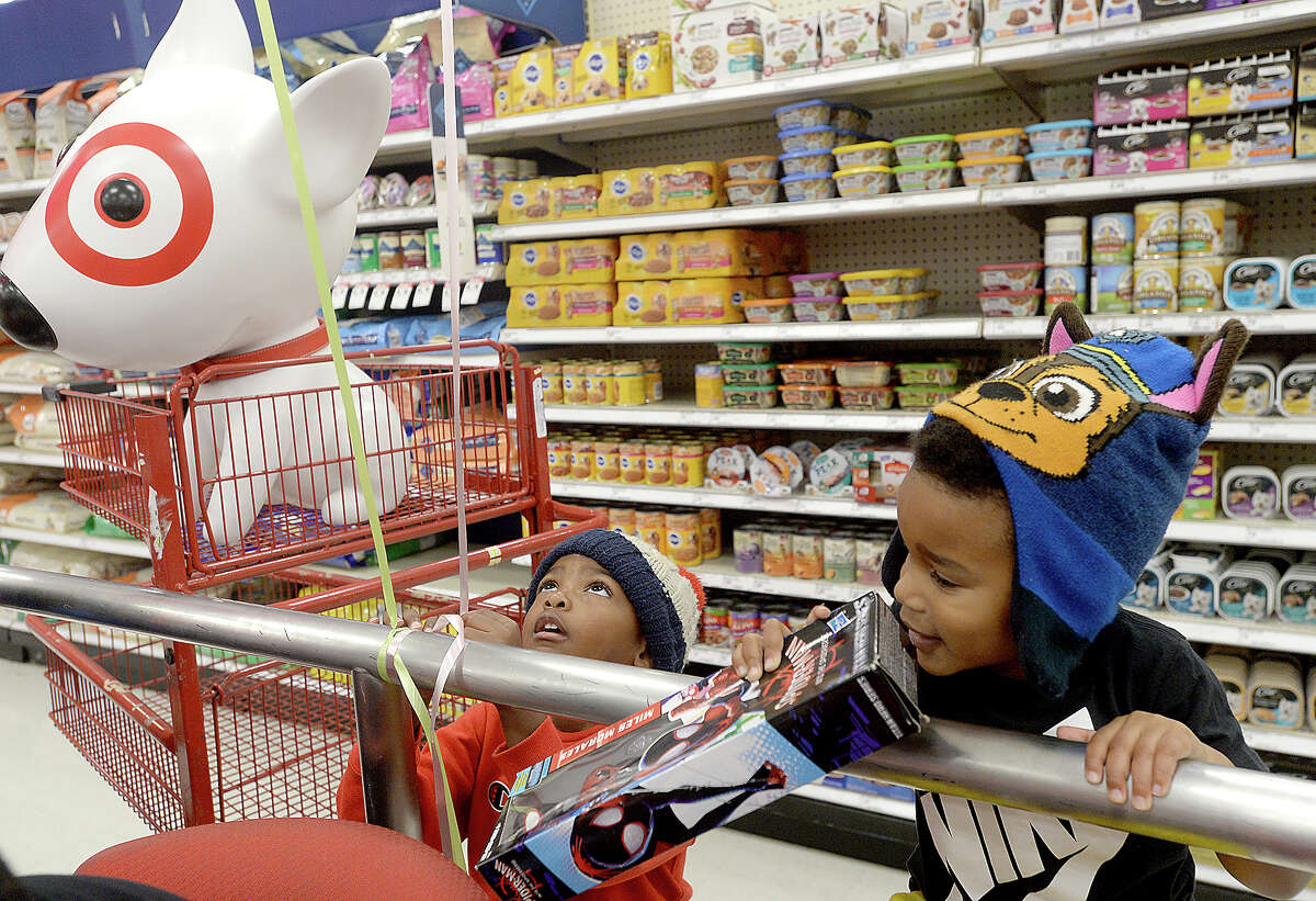 Trey Mouton looks up at the balloons overhead as he and Donnie Jackson hang out near their cartload of toys during Stephen Jackson's Christmas with a Champion event at Target Saturday. The Port Arthur native and former NBA champion donated gift cards to 100 families to purchase gifts for the holidays. Photo taken Saturday, December 8, 2018 Kim Brent/The Enterprise