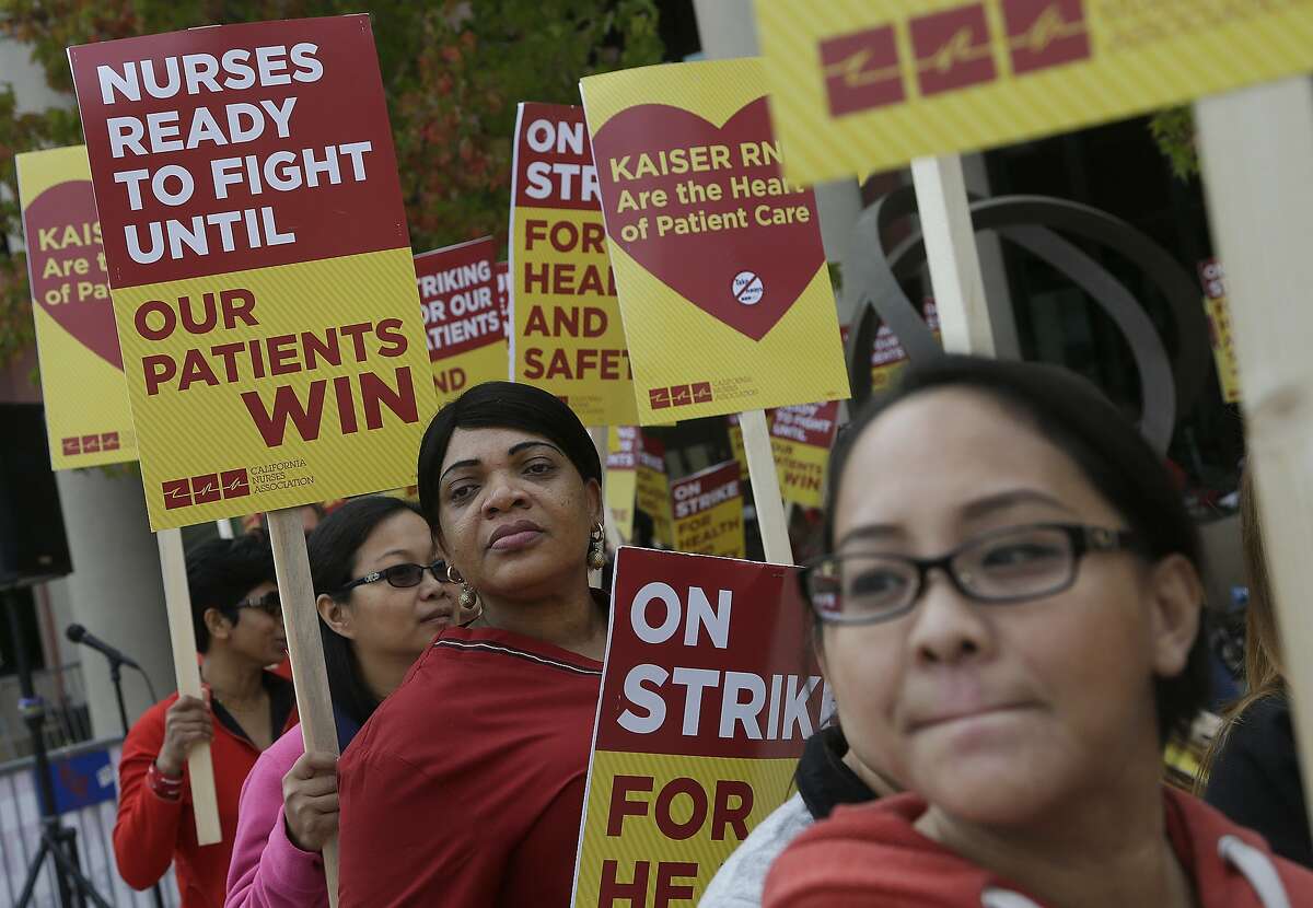 FILE - Registered nurses and supporters protest outside of a Kaiser Permanente facility in San Francisco on Nov. 11, 2014. As many as 18,000 nurses are participating in a statewide two-day strike to call attention to what they say is an erosion in patient care and lack of preparation for treating Ebola at Kaiser facilities.
