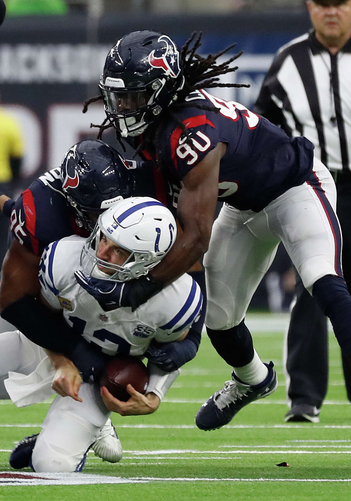Indianapolis Colts quarterback Andrew Luck (12) is sacked by Houston Texans defensive end Christian Covington (95) and Houston Texans outside linebacker Jadeveon Clowney (90) during the fourth quarter of an NFL football game at NRG Stadium, Sunday, Dec. 9, 2018, in Houston.