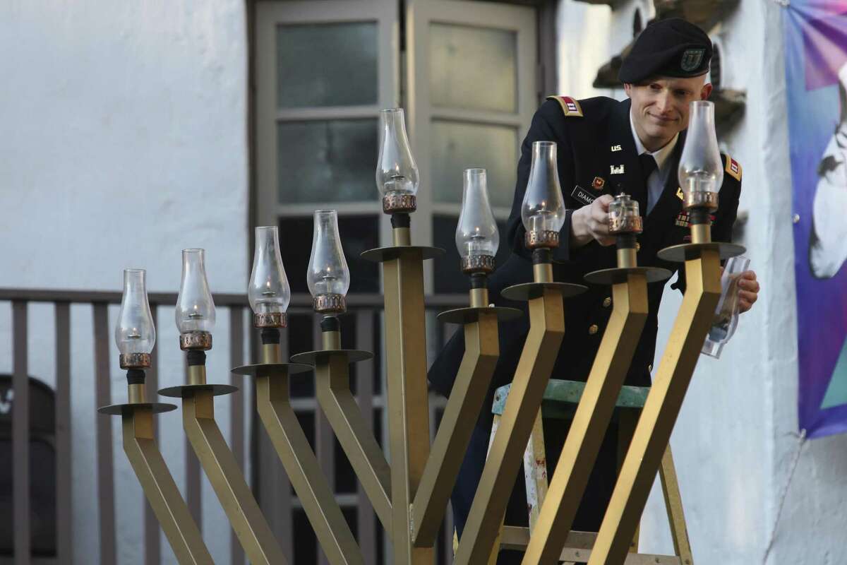 Capt. Ben Diamond helps light the menorah during the 21st. annual Chanukah on the River at the Arneson River Theatre, Sunday, Dec. 9, 2018. Chad Lubavitch of South Texas stages the event that included the included a concert by Brooklyn-based recording artist, Yoni Z.