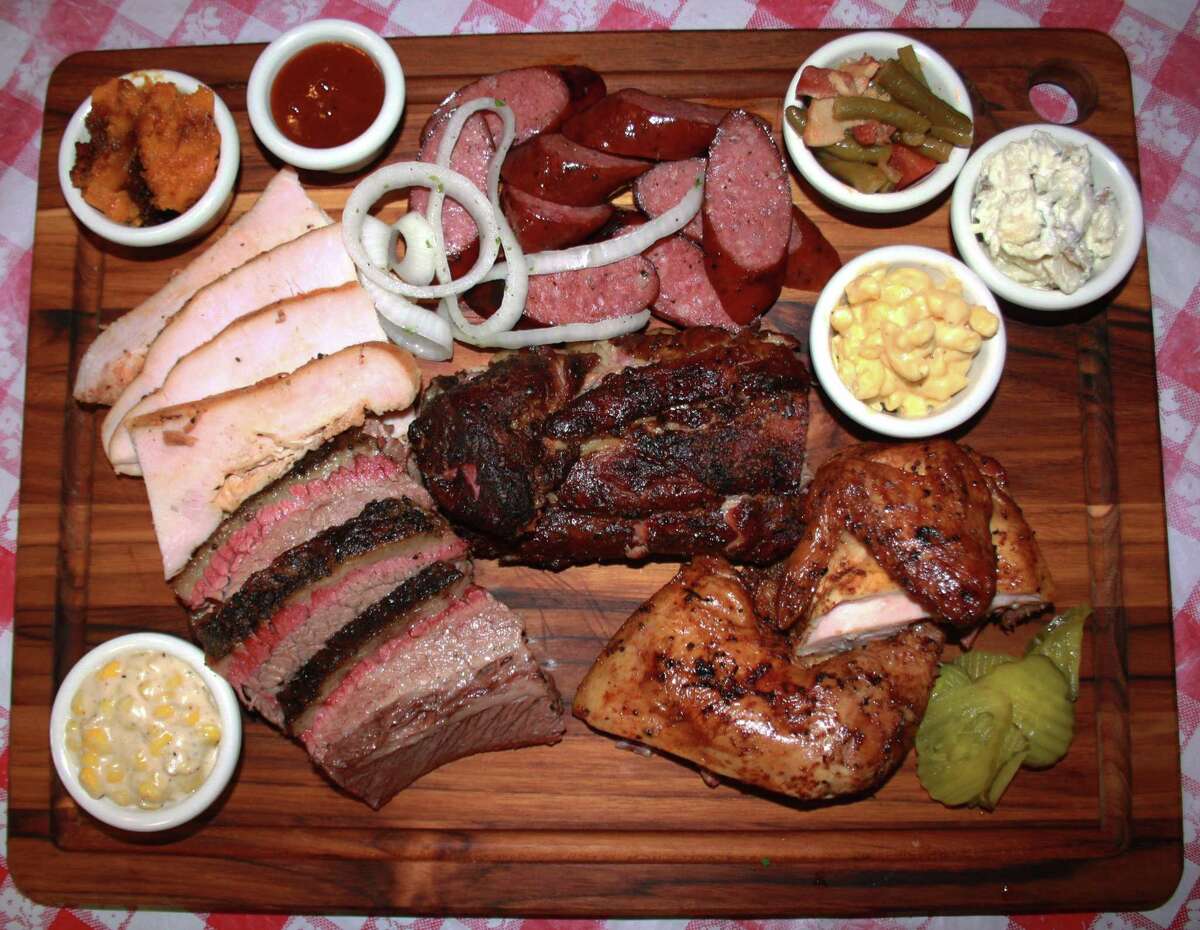 The Dee Willie's BBQ Smokehouse board includes (clockwise from top left): sweet potato casserole, sausage, green beans, baked potato salad, mac-n-cheese, smoked chicken, babyback pork ribs, brisket, creamed corn and turkey.