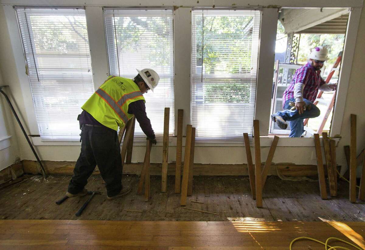 Barney Andrade (left), with Linbeck, removes the floor from one of the bungalows across the street from the Rothko Chapel, a first step in the demolition process. As much of the building as possible will be recycled, including the floor, as the bungalow is demolished to make way for a new Rothko Chapel visitors center on the site. The project is part of a master plan that also includes a major renovation of the chapel beginning in March.