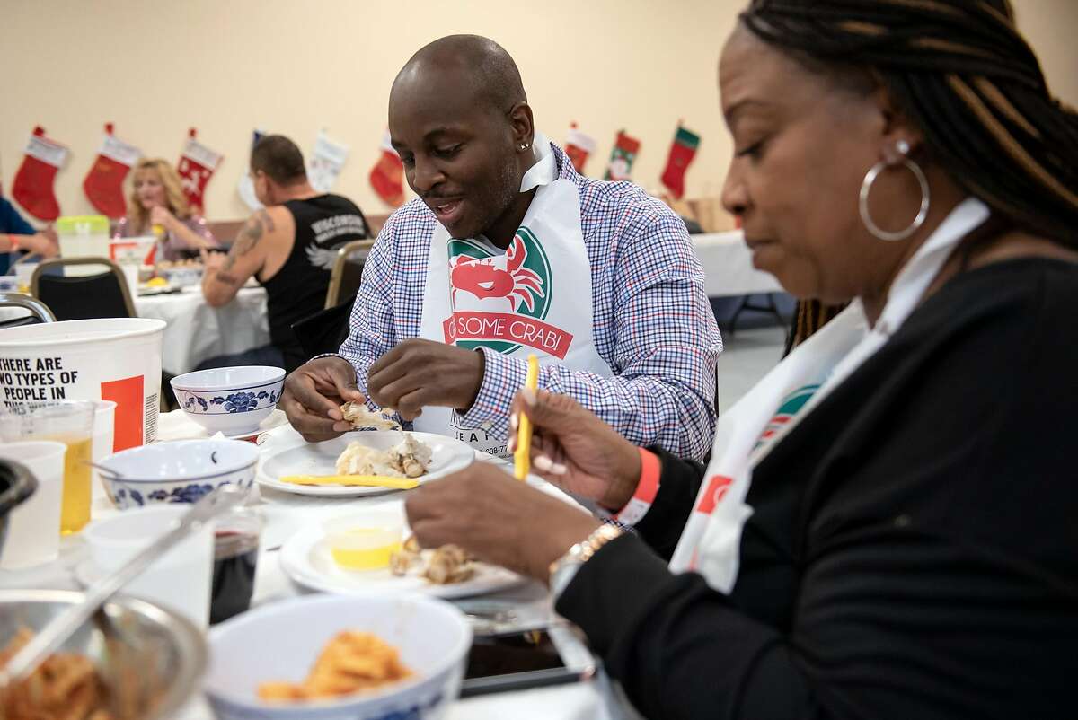 Guests Cornell Keeles and Jennifer Brown dig into their meals during a crab dinner fundraiser held to support Castro Valley High School, at the Castro Valley Moose Lodge in Castro Valley, California, on Saturday, December 8, 2018.