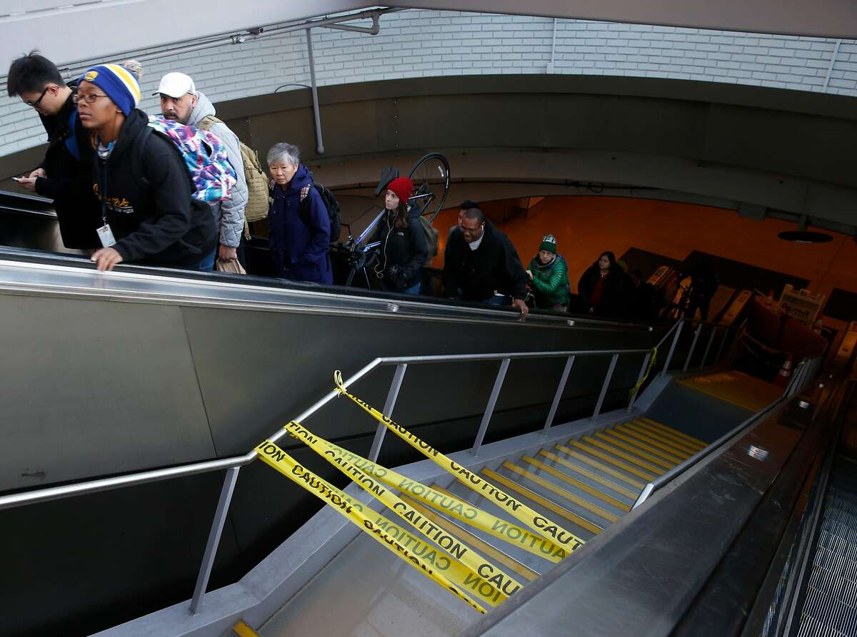 Commuters ride an elevator past a glass staircase that remains closed to the public at the main entrance Downtown Berkeley BART station in Berkeley, Calif. on Tuesday, Dec. 11, 2018. A new glass canopy and stairway opened recently after an extensive redesign but a commuter fell on the steps after recent rains created slippery conditions.