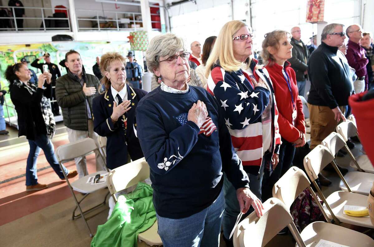 Wendy Cowles (center left) of East Haven and her sister, Barbara Cowles (center right) of Branford attend a ceremony for a convoy of Wreaths Across America trucks from Maine carrying over 250,000 donated wreaths headed to Arlington National Cemetery that stopped at the Branford Fire Department on December 11, 2018.