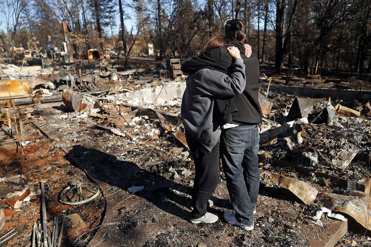 In the aftermath of the Camp Fire, Linda Haddock and her son, Jake Belculfino, embrace as they look through the remains of their house along Pentz Road in Paradise, Calif. on Thursday, December 6, 2018.