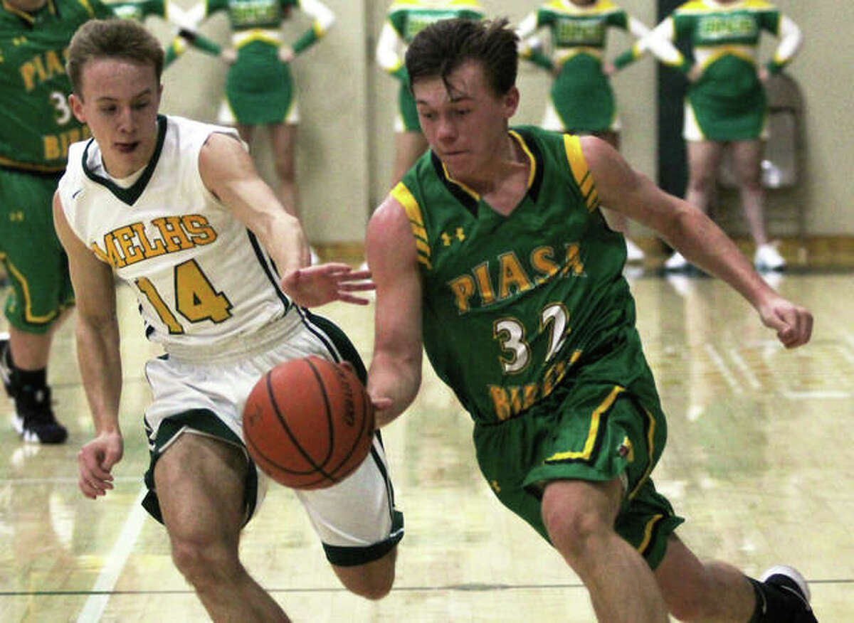 Southwestern’s E.J. Kahl (right) drives past Metro-East Lutheran’s Jonah Wilson during the first half of a nonconference boys basketball game Tuesday night at Hooks Gym in Edwardsville.