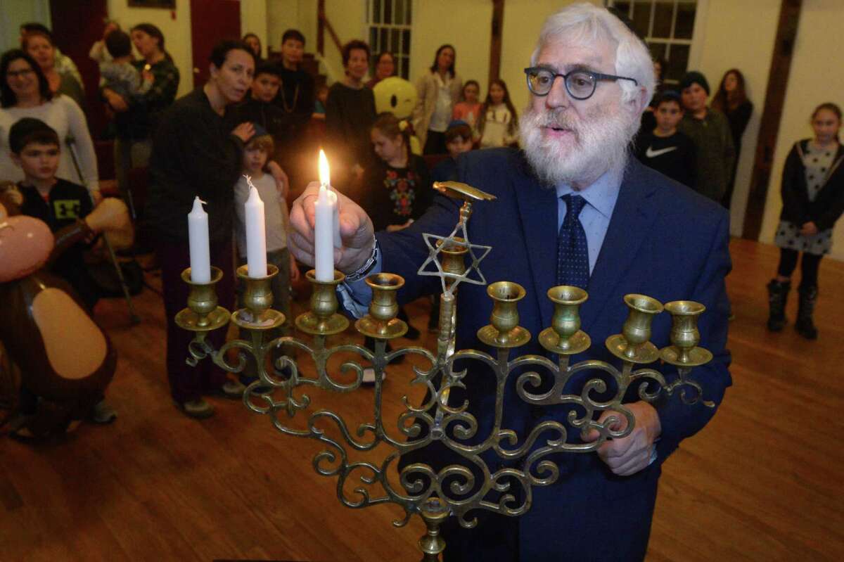 Rabbi Hecht lights the menorah during the Weston/Westport Hebrew School Family Fun Chanukah Event Tuesday evening, December 4, 2018, at the Norfield Grange in Weston, Conn. The event included refreshments and a Menorah lighting ceremony. The Weston/Westport Hebrew School is accepting registration for its new semester that begins Tuesday, January 8, 2019. The after school Hebrew schedule features the very popular Aleph Champ Hebrew reading and writing program for first through seventh graders with a special curricula for kindergartners. The program also prepares students for Bar and Bat Mitzvah and includes art, music and a thematic curriculum that imparts the joy of Judaism to its students.