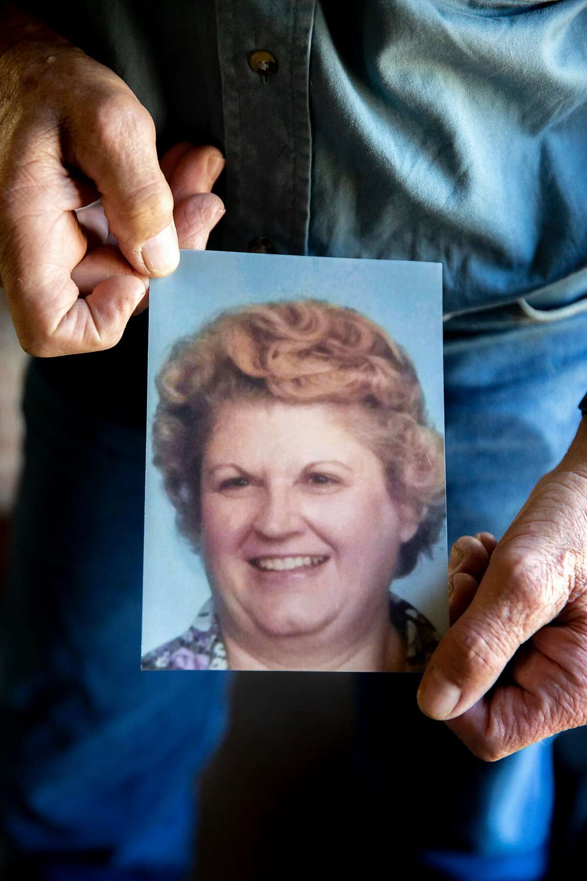 Walker holds a photo of Ellen, 73. The remains of Victim No. 53 were found with hers. Photo: Santiago Mejia / The Chronicle