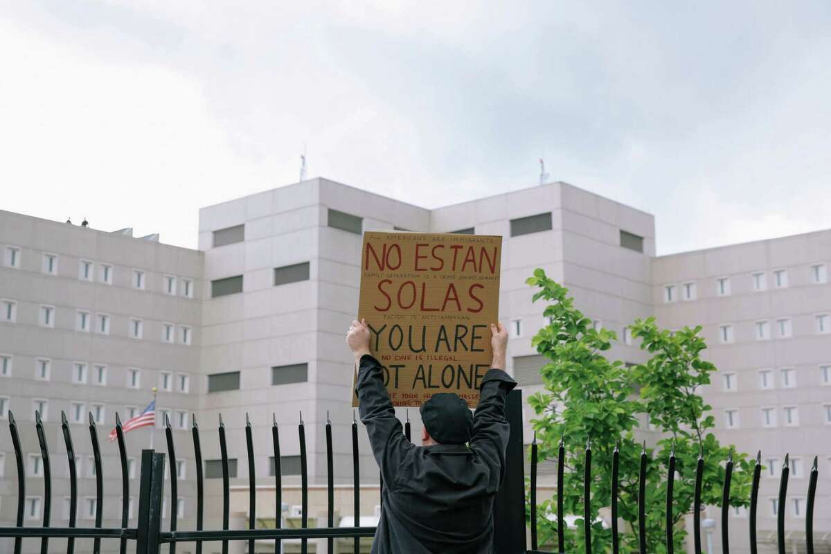 Peter Smalley holds a sign reading "You are not alone" in both English and Spanish as he and several thousand protesters and elected officials including Washington State Governor Jay Inslee, State Attorney General Bob Ferguson and U.S. Rep. Pramila Jayapal (D-Seattle), gather at the Federal Detention Center in SeaTac where 174 women are being held, most of whom fled Central America to seek political asylum in the U.S., June 9, 2018. According to Jayapal, who met with the women Saturday, many said their children were taken from them after they crossed the border into Texas. The protest included speeches, sign making, letter writing, and music.