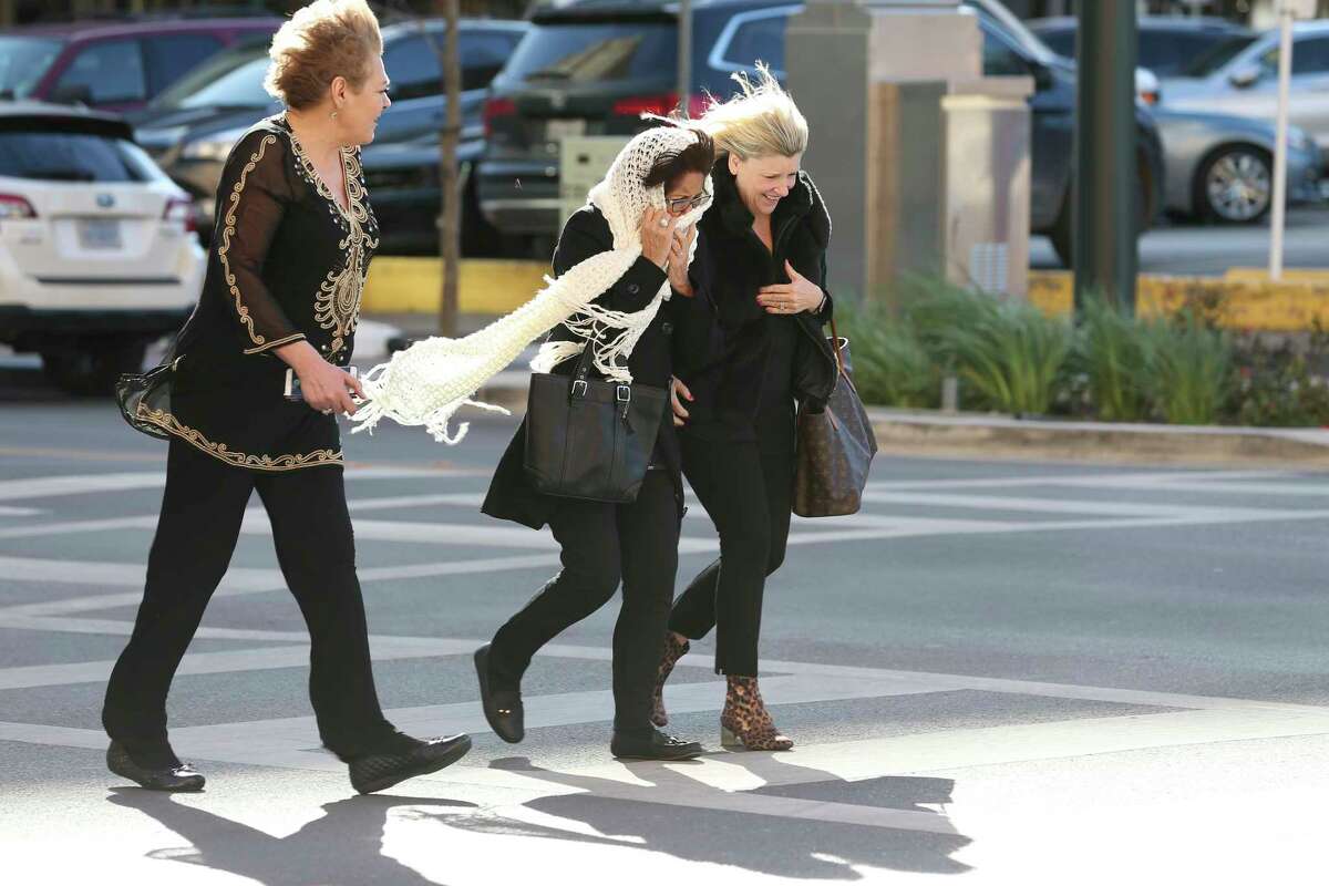 Pedestrians battle wind gusts in downtown San Antonio, Thursday, Dec. 13, 2018. According to the National Weather Service, winds were gusting up to 40 mph in the San Antonio area with gust up to 50 in Del Rio and Eagle Pass, Texas.