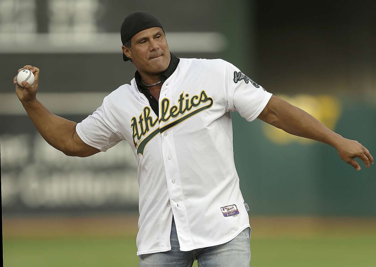 FILE - In this Sept. 3, 2016, file photo, former Oakland Athletics player Jose Canseco throws out the ceremonial first pitch prior to a baseball game against the Boston Red Sox in Oakland, Calif. Canseco, a former major league slugger, has made his pitch for a big job at the White House, tweeting Wednesday, Dec. 12, 2018, to U.S. President Donald Trump: "u need a bash brother for Chief if (sic) Staff." (AP Photo/Ben Margot, File)