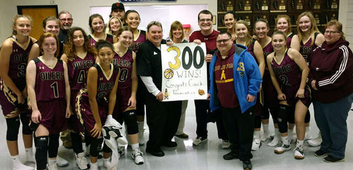 The EA-WR Oilers girls basketball team celebrates coach Joe Parmentier’s 300th career victory as a basketball coach on Thursday night after EA-WR’s victory in the Candy Cane Classic at Waterloo Gibault.