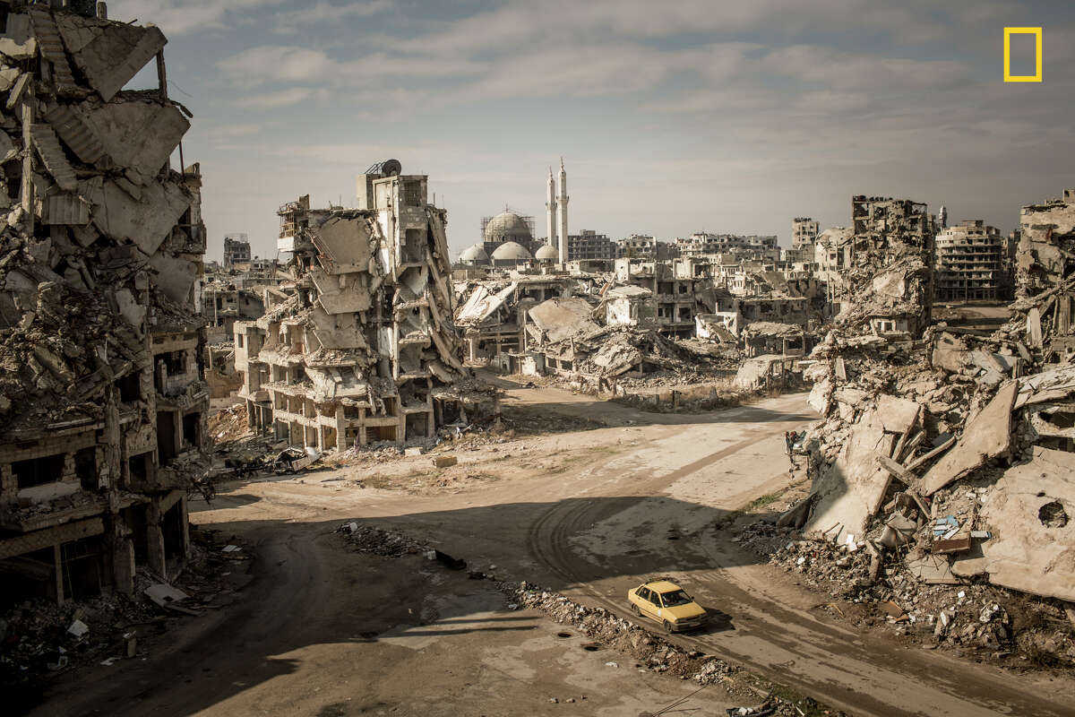 Winners of the 2018 National Geographic Photo Contest, 3rd Place, Places While on assignment for Der Spiegel, we made a road trip through Syria to document the current situation in major cities. When I firstentered the Khalidiya district in Homs, I was shocked. I hadn't seen such large-scale destruction before, and I had been to many destroyed cities. The area around the Khalidiya district was extremely quiet. No city sounds, cars—nothing. Only the chirping of swallows and the wind.We walked down the streets of Khalidiya, but the destruction was so large scale that you couldn't have the big picture from the point of view on the street—you could only manage it with a view from above. To make this image, I asked a Syrian soldier in charge of the area if I could climb onto a ruin. The soldier agreed, allowing me to climb at my own risk. I climbed up the ruins of a former house—which was full of improvised explosive devices—and took the picture. I was very lucky to take the picture when I was on the rooftop. Without any sign of life, it would have been a dead picture. I can recall the memory vividly. Link: https://yourshot.nationalgeographic.com/photos/10486526