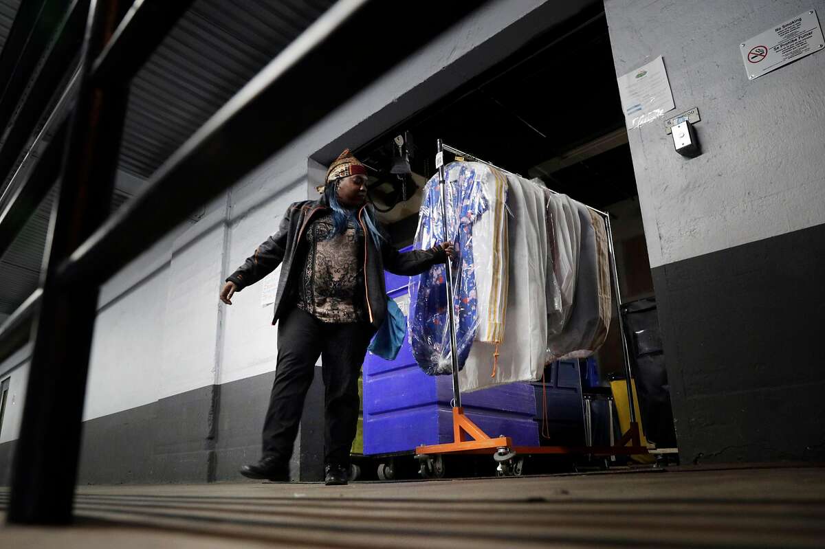 LaDasha Berry brings out a rack with cleaned and pressed clothes ready to be delivered to thier owners at Rinse, an on-demand laundry service in San Francisco, Calif., on Thursday, December 13, 2018. Rinse is a startup that provides an on-demand laundry service. The company picks up laundry from clients and delivers it to the warehouse and partners with local laundry services to wash the clothes.