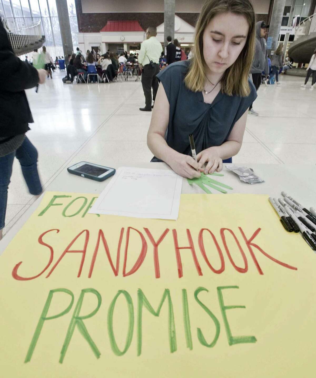 Elizabeth Casolo, a sophomore, writes a kindness note at the Roots and Shoots table in the student center at Greenwich High School, for the anniversary of the Sandy Hook shooting. Friday, Dec. 14, 2018