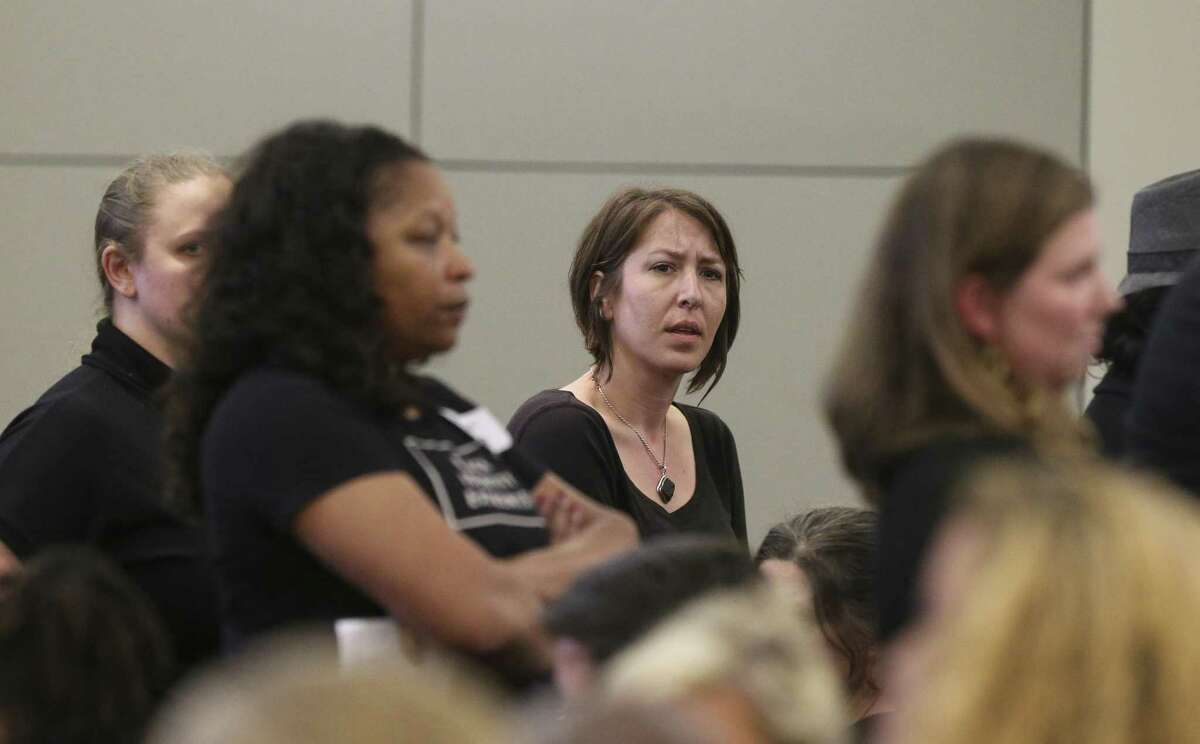 Houston Independent School District board meeting attendees turn their backs against the turstees and show frustration when trustees speak in favor to potentially seeking outside partners to run several long-struggling schools during a HISD meeting on Thursday, Dec. 13, 2018, in Houston.