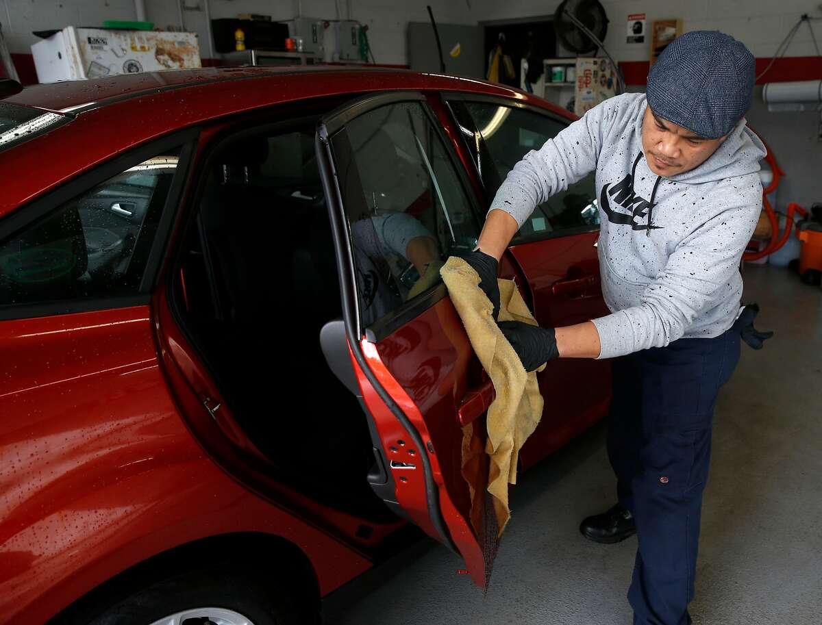 Edmon Aguiluz details a new car for delivery to a customer at the Serramonte Ford dealership in Colma, Calif. on Friday, Dec. 14, 2018. Beginning Jan. 1 auto dealerships will be required to affix temporary license plates to every vehicle sold and before it drives off the lot.