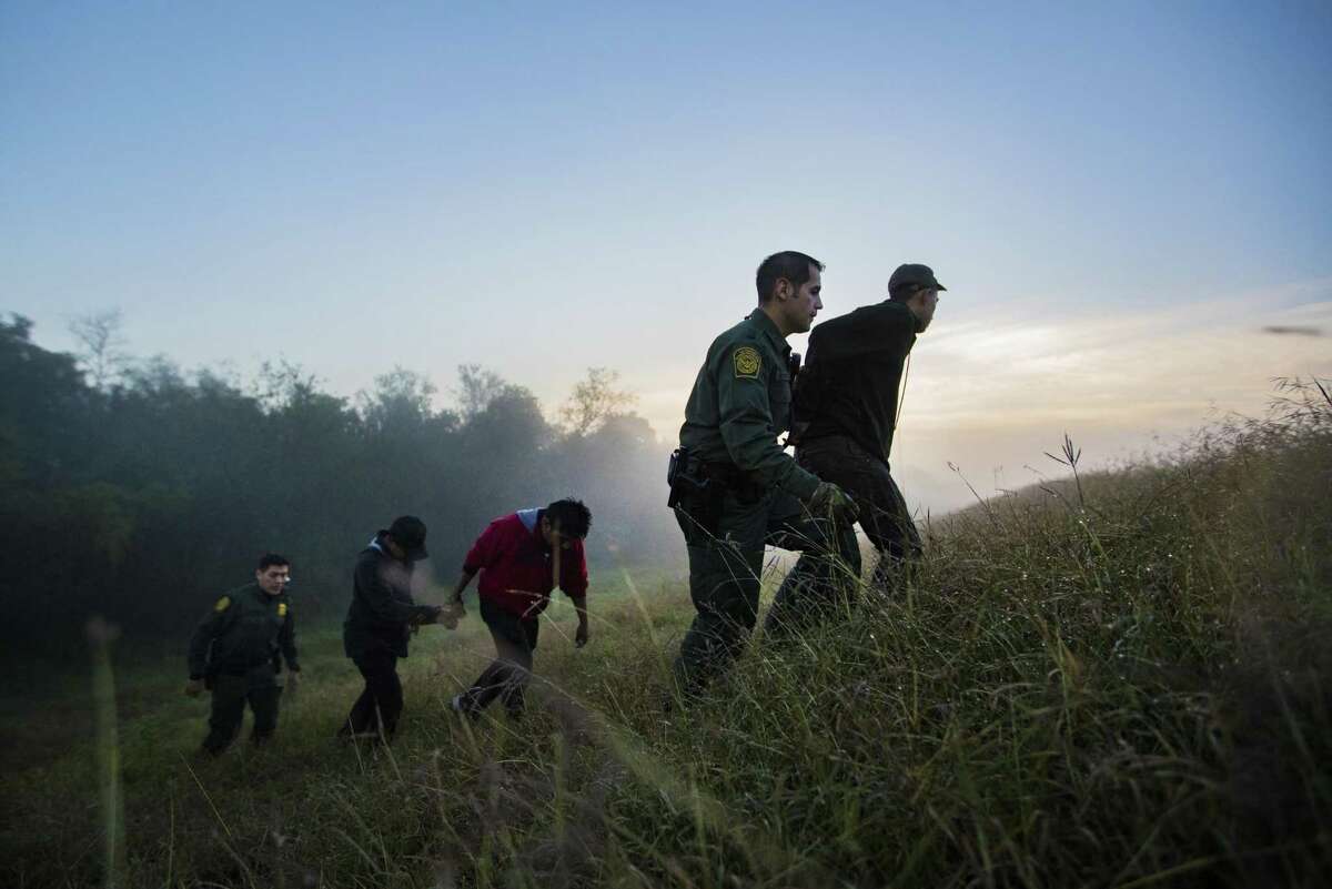 Five young men are detained by Border Patrol agents near the Rio Grande River on Thursday, Dec. 13, 2018, in Mission. The group tried to escape after they were intercepted hiding in the bushes.