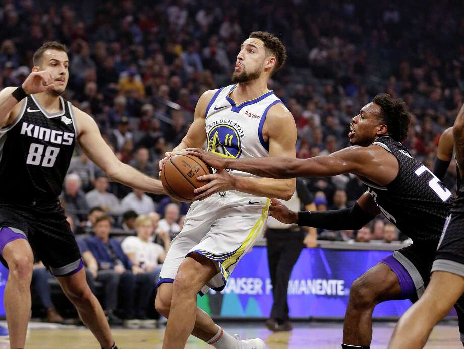 Golden State Warriors guard Klay Thompson, center, drives to the basket between Sacramento Kings' Nemanja Bjelica, left, and Buddy Hield, right, during the first half of an NBA basketball game Friday, Dec. 14, 2018, in Sacramento, Calif. Photo: Rich Pedroncelli, AP / Copyright 2018 The Associated Press. All rights reserved
