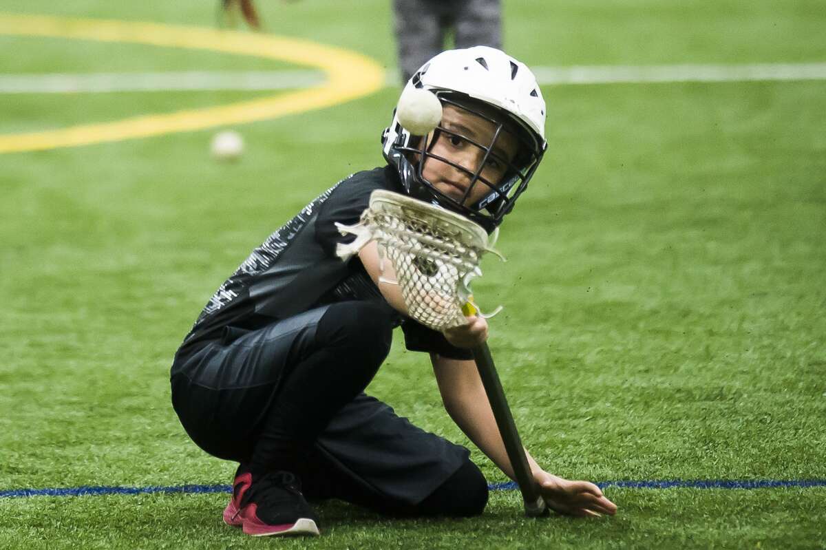 Josiah Vajcner of Midland, 7, practices scooping the ball during a "Try Lacrosse Free" event hosted by the Midland Lacrosse Club on Saturday, Dec. 15, 2018 at Midland Civic Arena. (Katy Kildee/kkildee@mdn.net)