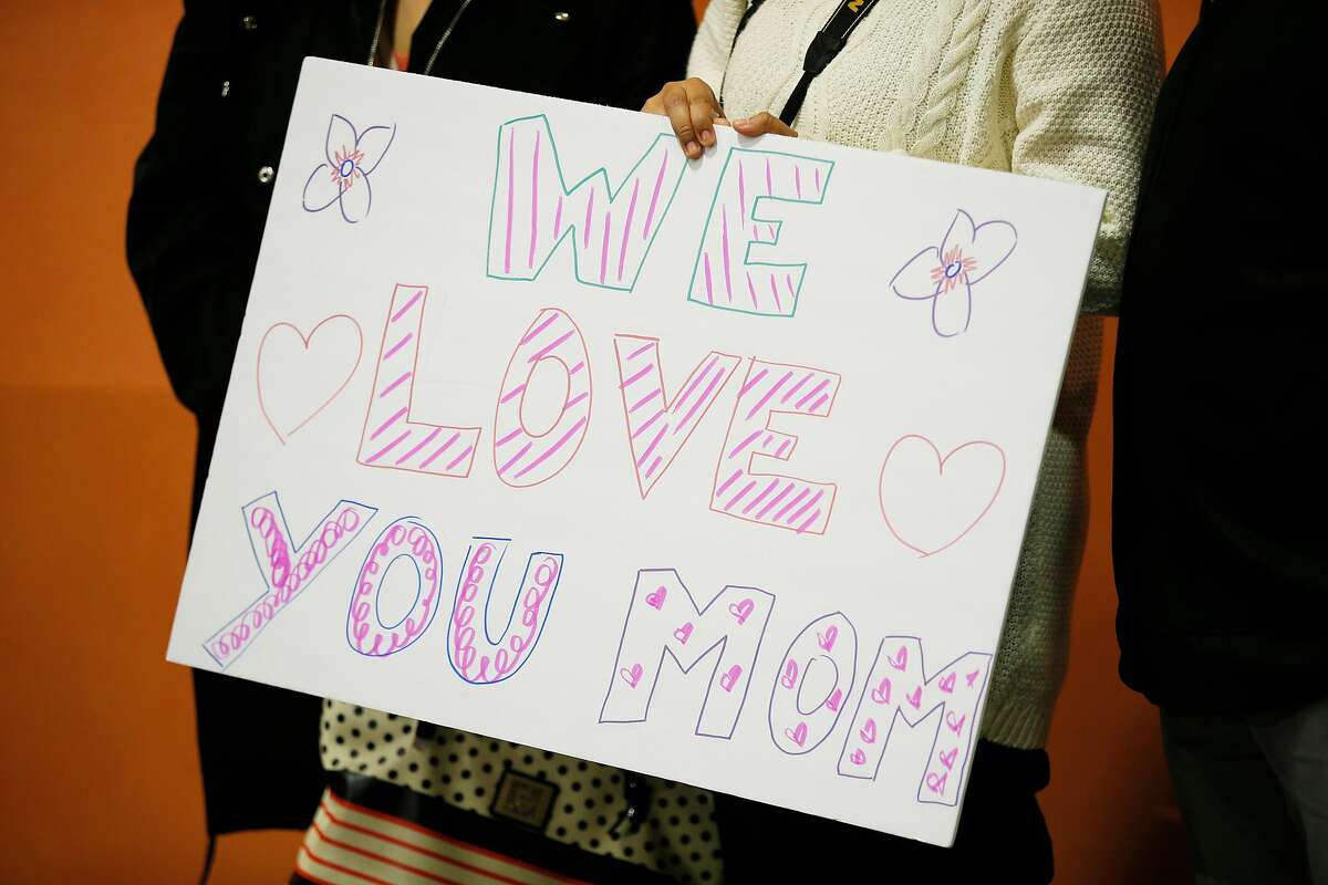 Melin Sanchez holds a sign she brought to welcome her mother Maria Mendoza-Sanchez at SFO on Saturday, Dec. 15, 2018, in San Francisco, Calif. Mendoza-Sanchez, a nurse who was separated from her children and deported to Mexico last year after more than two decades in Oakland, won her improbable fight to return to the United States. Her visa was approved by U.S. Citizenship and Immigration Services.