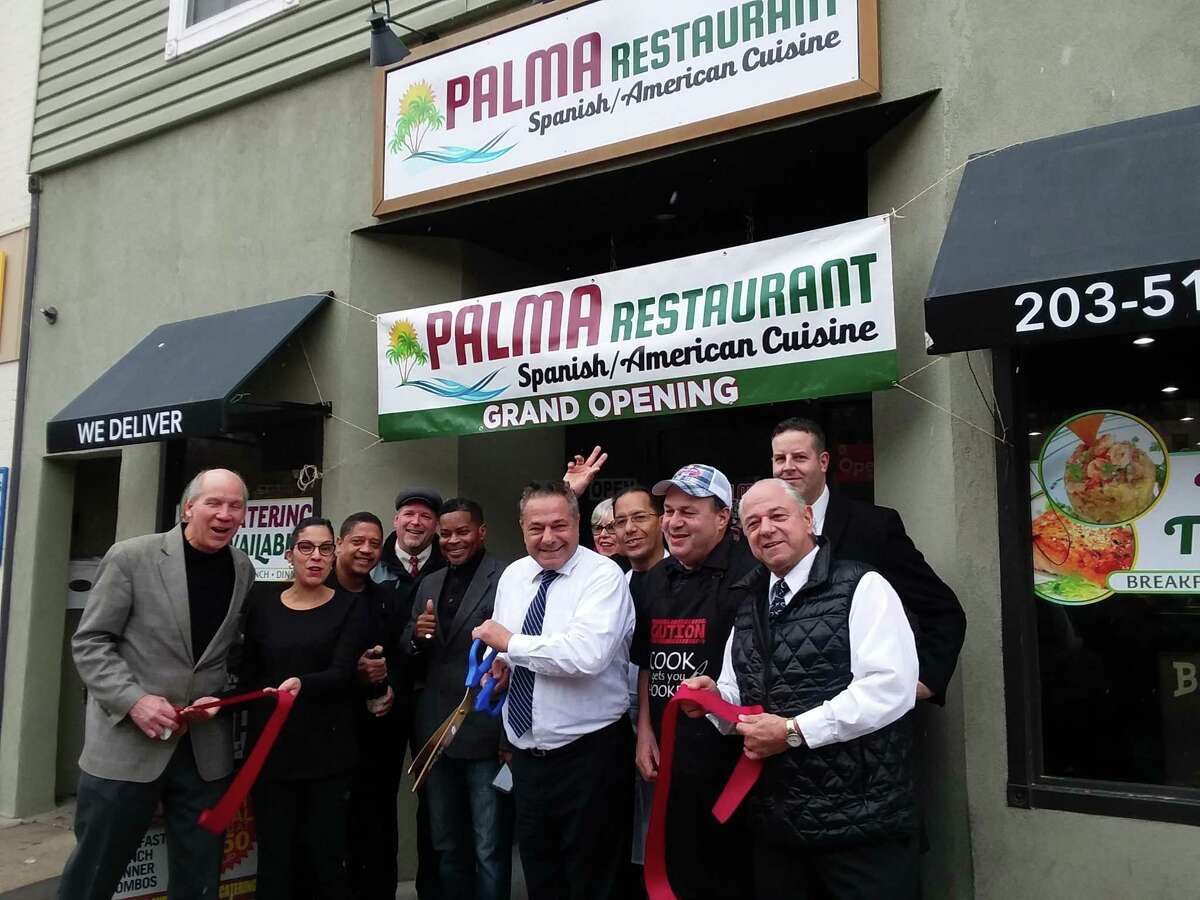 Mayor David Cassetti helps cut the ribbon on Palma Restaurant
