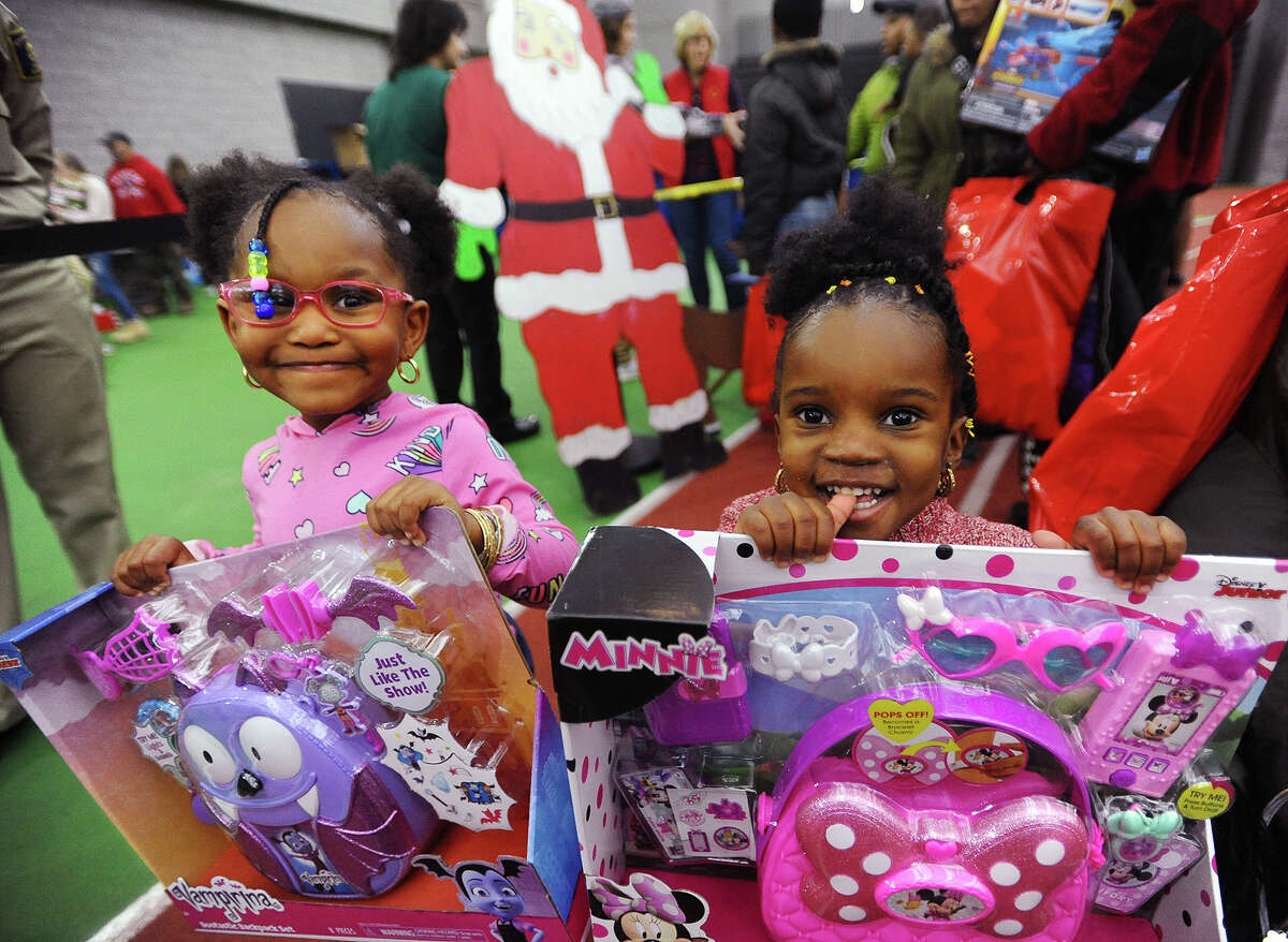 R-Mani Johnson, 3, left, and Aloni Harmon, 2, of New Haven, with their toys at the 5th Annual Winter Wonderland holiday toy giveaway at the Floyd Little Fieldhouse in New Haven, Conn. on Sunday, December 16, 2018.