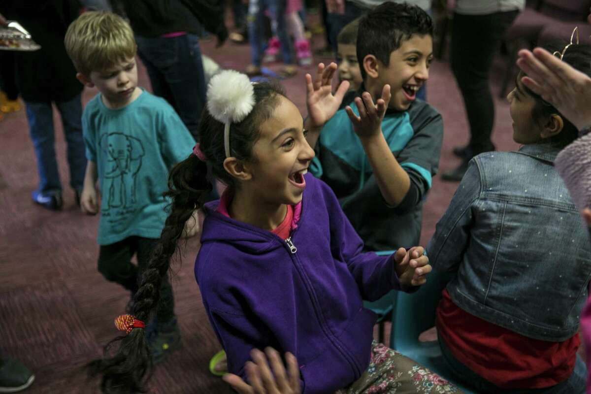 Children erupt in laughter while playing a game of musical chairs during a Christmas party for refugee families and their children hosted by the Center for Refugee Services and Resurgent Church at the church, Dec. 15, 2018. Volunteers handed out donated gifts to children whose families have recently resettled in San Antonio.