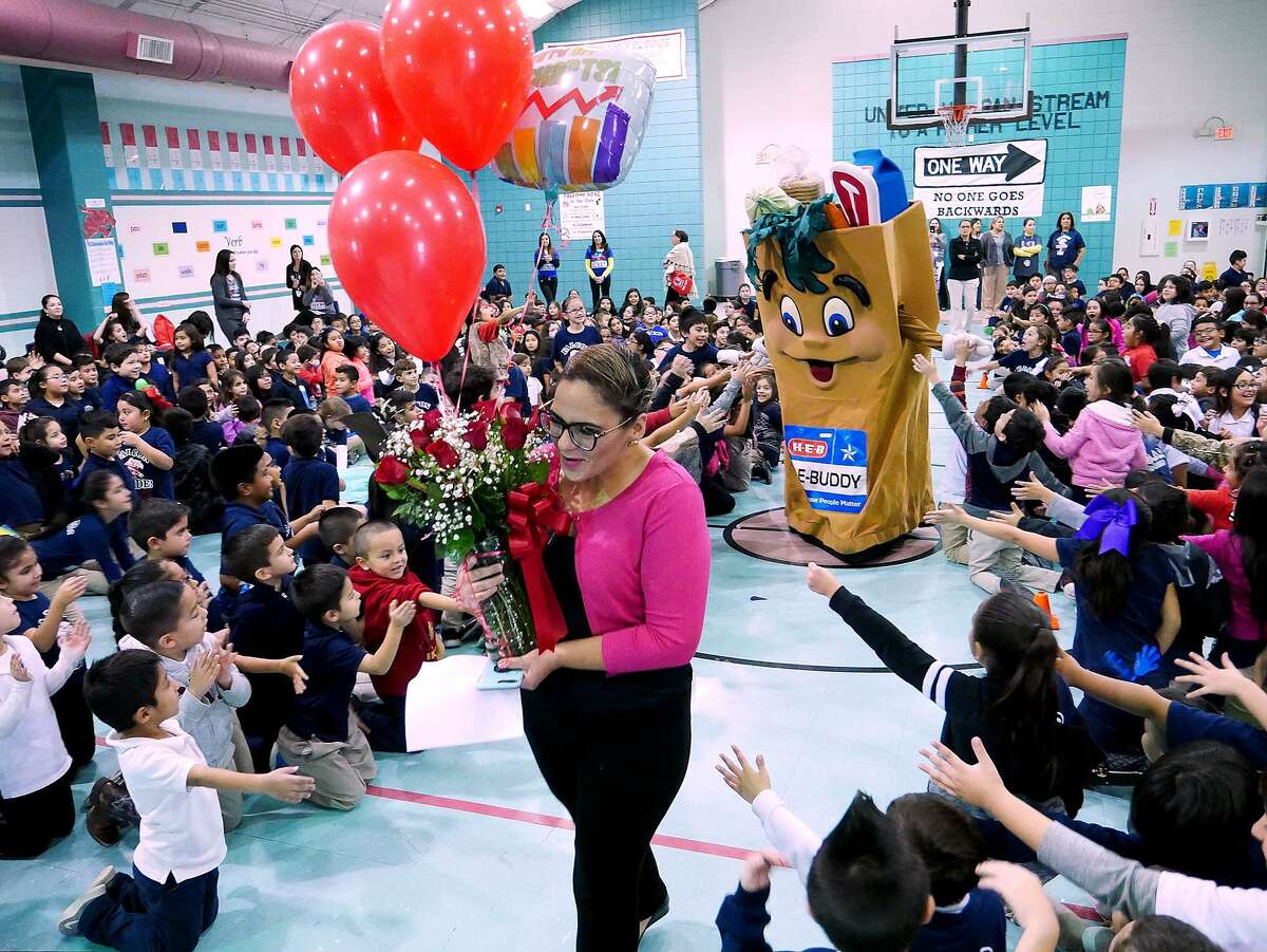 HEB Store Director Viridiana Fernandez and HEBuddy make their way into the gymnasium at Muller Elementary Friday, November 16, 2018 where they presented a check for $1,000 to the school library to purchase books for being named the 2018 Read 3 Regional School Book Drive Challenge Champion.
