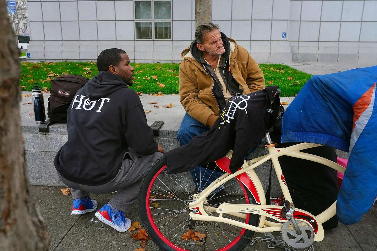 HOT team member Cedric Bowser, left, talks with homeless man Ron Quasebarth as he tries to set him up to enter a navigation center, in San Francisco, California, on Monday, December 17, 2018.