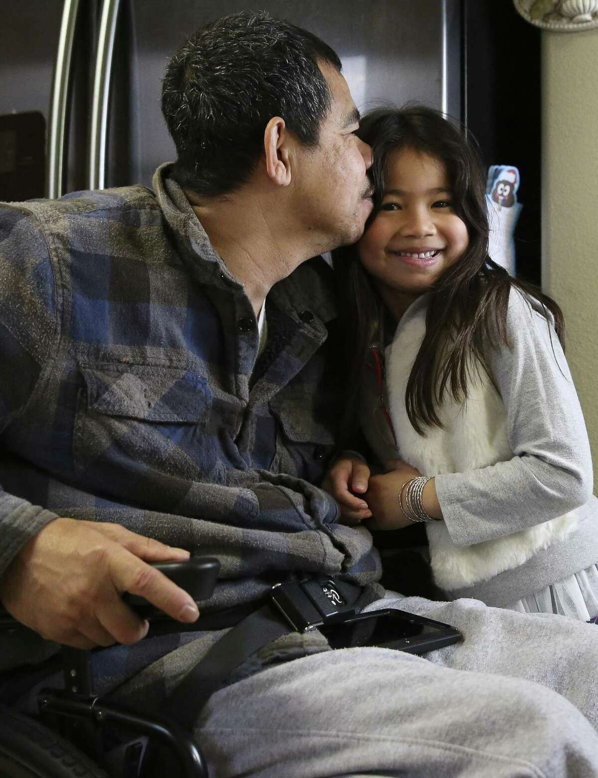 Khanh Hung Le, 47, kisses his daughter, Tonya, 7, when she comes home after school. Le has raised his daughter since she was 7 months old after he separated from his ex-wife.