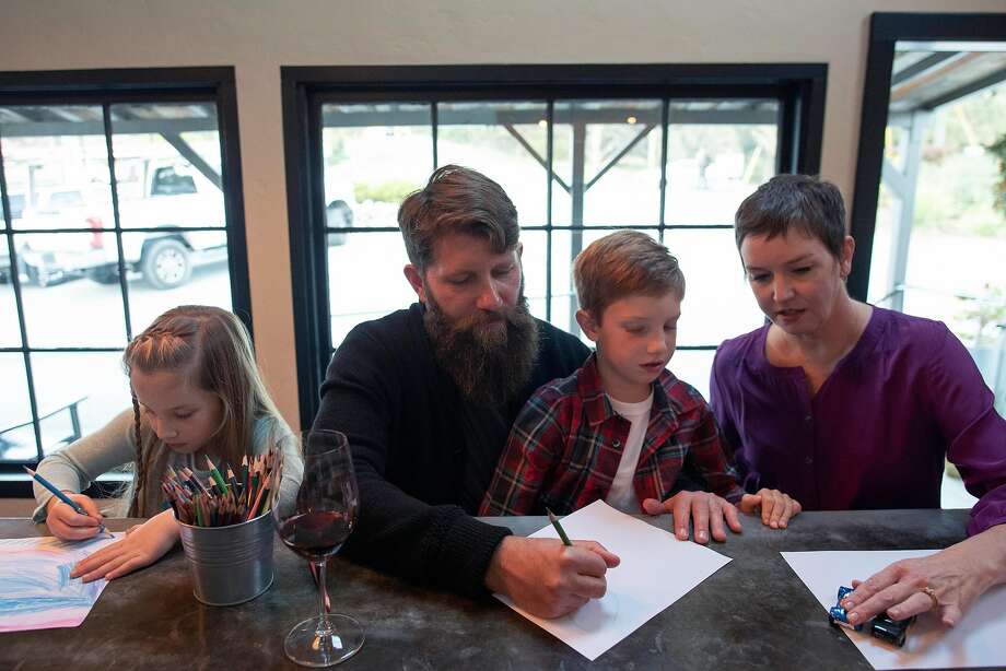 Ian and Heather Brand draw pictures with their twins, Eleni (left) and Isaak at the Brand's tasting room in Carmel Valley, Calif. Photo: Nic Coury / Special To The Chronicle