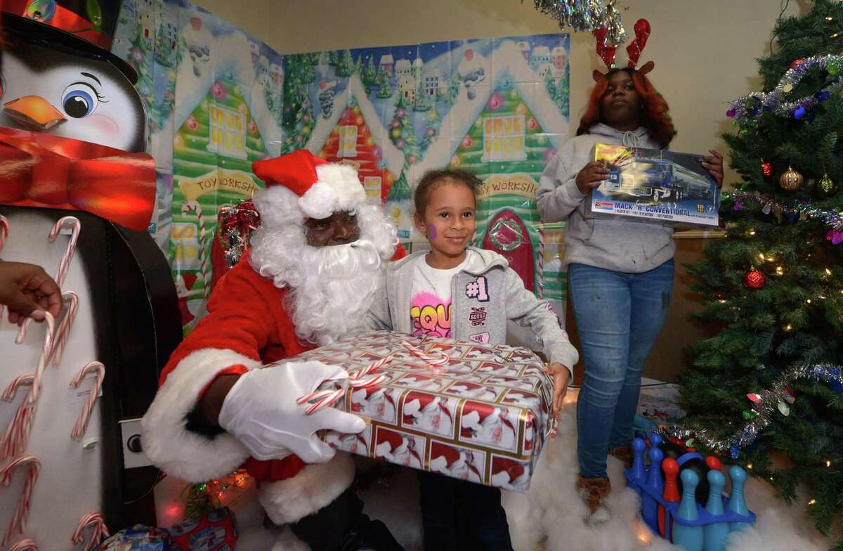Children including Naliyah DeLeon, 5, visit with Santa, aka James Dupree, and receive a gift during the DDH Hope Foundation Inc. 4th annual Fund A Family Christmas Party event Saturday, December 15, 2018, at the South Norwalk Community Center. Over a hundred needy children were served during the annual event.