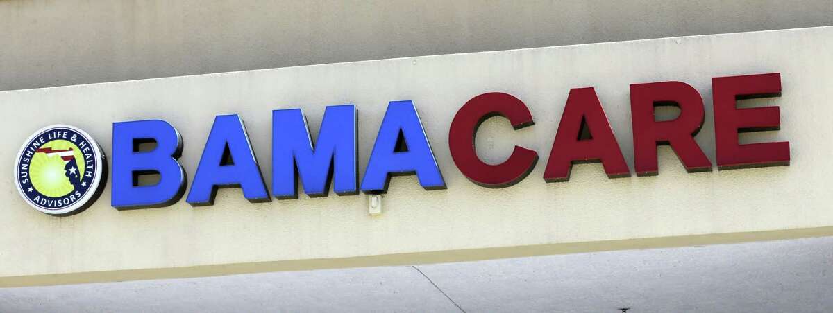 File- This May 11, 2017, file photo shows an Obamacare sign being displayed on the storefront of an insurance agency in Hialeah, Fla. A conservative federal judge in Texas on Friday, Dec. 14, 2018, ruled the Affordable Care Act ?“invalid?” on the eve of the sign-up deadline for next year. But with appeals certain, even the Trump White House said the law will remain in place for now. In a 55-page opinion, U.S. District Judge Reed O?’Connor ruled Friday that last year?’s tax cut bill knocked the constitutional foundation from under ?“Obamacare?” by eliminating a penalty for not having coverage. The rest of the law cannot be separated from that provision and is therefore invalid, he wrote. (AP Photo/Alan Diaz, File)