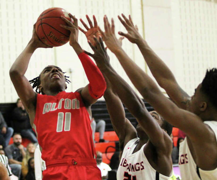 Alton’s Donovan Clay (left) puts up a shot over a pair of Jennings defenders in the Redbirds’ loss Saturday at the Ramey Shootout in Webster Groves. The Redbirds returned to SWC action Tuesday night and won at Belleville East. Photo: Greg Shashack / The Telegraph