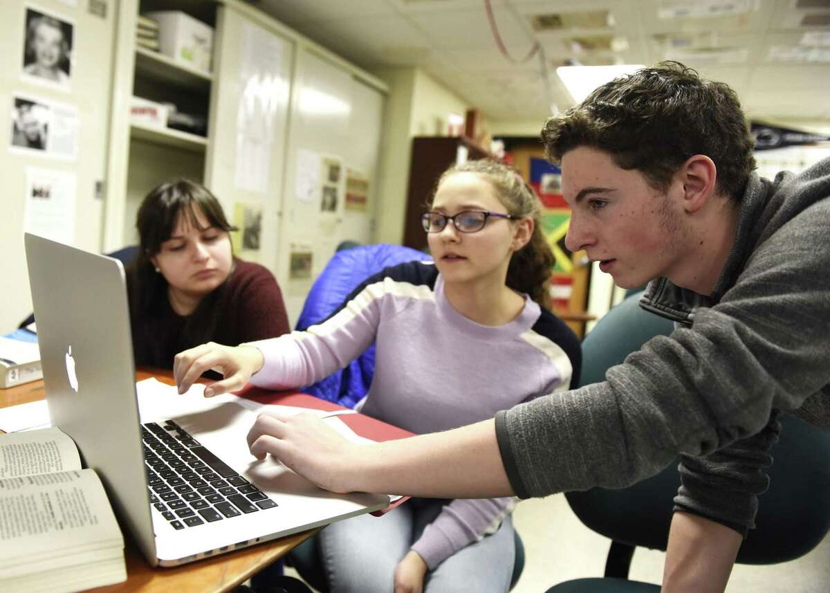 News Editor Emma Sharma, left, Co-Editor In Chief Shayna Druckman, center, and Multimedia Editor Sam Diamond work on The Round Table student newspaper after school at Stamford High School in Stamford, Conn. Tuesday, Dec. 18, 2018. The online news publication was recently awarded gold medal status by the Columbia Scholastic Press Association.