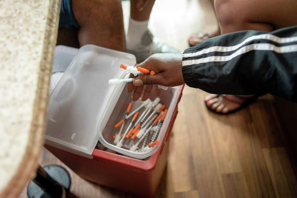 A client turns in 50 used needles in exchange for 50 new ones at a needle exchange center in Washington.