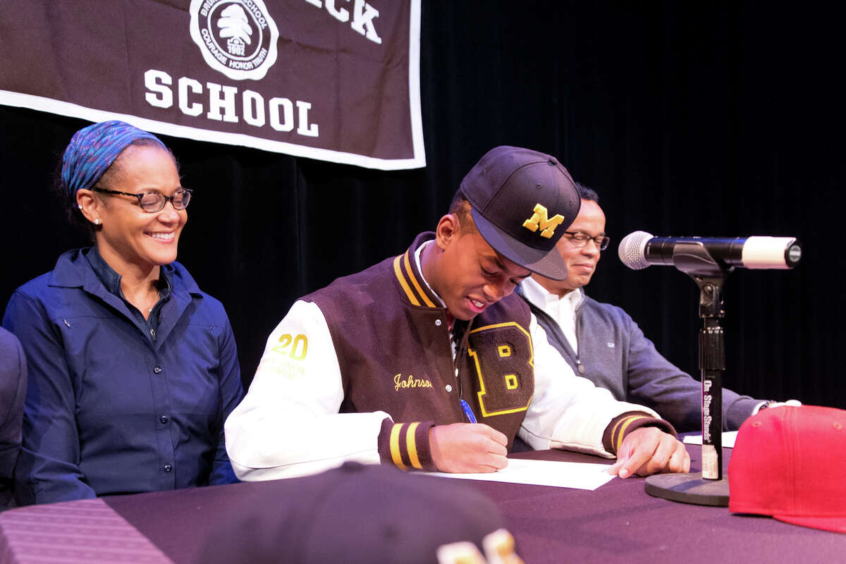 Cornelius Johnson signs to play football at Michigan during his signing day ceremony at Brunswick on Wednesday, Dec. 19, 2018.