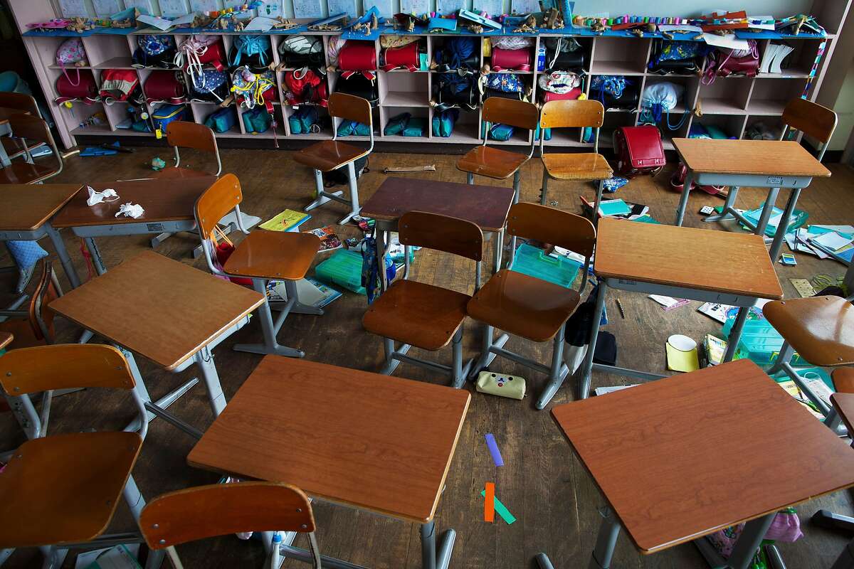 In this June 19, 2011 file photo, children's desks, backpacks, and school supplies lie abandoned inside an earthquake-rattled primary school classroom in Namie, Japan. The photo was one in a series of 12 which won the 3rd place prize in the General News Stories category of the 2012 World Press Photo contest. (AP Photo/David Guttenfelder for National Geographic Magazine, File)