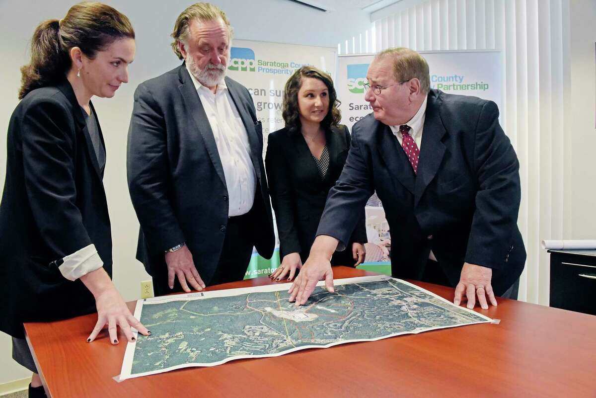 Shelby Schneider, left, VP of Saratoga County Prosperity Partnership, Marty Vanags, second from left, president of Prosperity Partnership and Jennifer Kelley, third from left, an economic development assistant with Prosperity Partnership, look over a map of Luther Forest with Kelley's father, Jack Kelley, director of economic development at Prime Companies, on Wednesday, Dec. 19, 2018, in Malta, N.Y. (Paul Buckowski/Times Union)