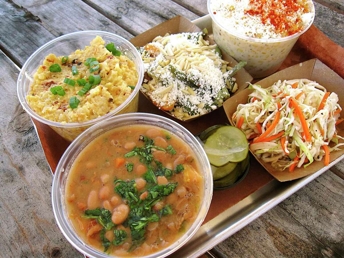 Side dishes of borracho beans, loaded tater tor casserole, green bean salad, creamed corn, slaw and pickles from South BBQ & Kitchen.