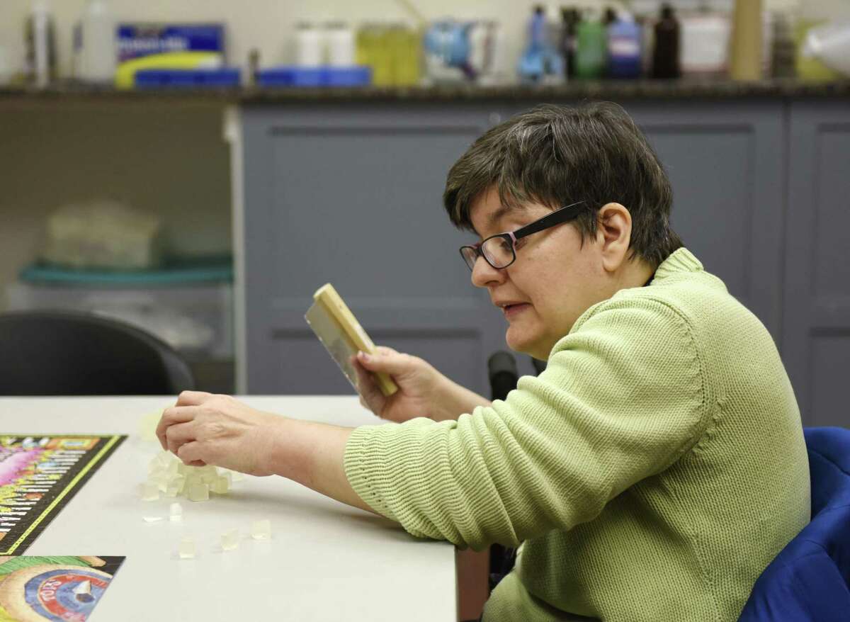 Abilis client Deborah Misagno cuts soap to be sold at Abilis Gardens & Gifts in the Glenville section of Greenwich, Conn. Tuesday, Dec. 18, 2018. The shop offers a variety of holiday gifts, including candles and bath products handmade by Abilis clients. The store has been open since 2012 but underwent renovations last fall and now is functioning as a job training area to give clients experience working a cash register and interacting with patrons. It is open from 10 a.m. to 5 p.m. Monday through Saturday and 10 a.m. to 7 p.m. on Thursday.